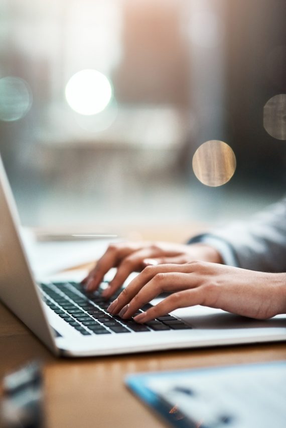 Closeup shot of an unrecognizable businesswoman using a laptop in an office.